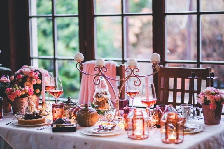 Een elegant aangeklede eettafel voor private dining met vrienden, met bloemen en kaarsen als decoratie