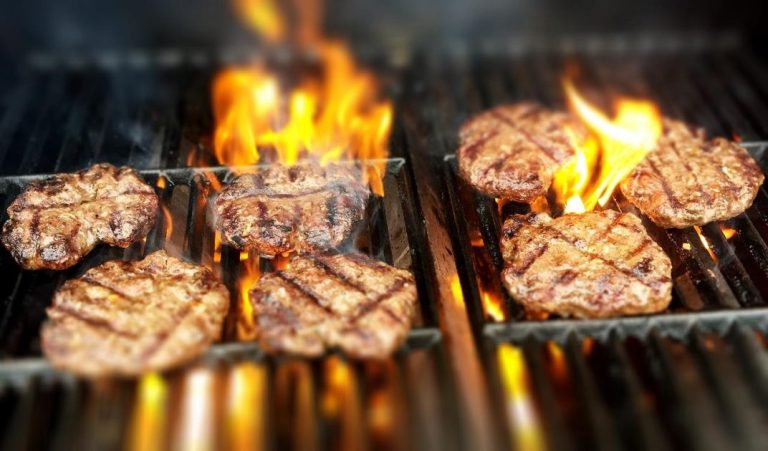 Home Nederlands barbecue assortiment met worstjes, hamburgers en spiesjes op de grill, populaire BBQ-gerechten